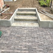 Totaalproject te Brasschaat - Plaatsen van kleiklinker terras, trap in blauwe hardsteen, keerwanden in beton, inclusief draadafsluiting en beplantingen